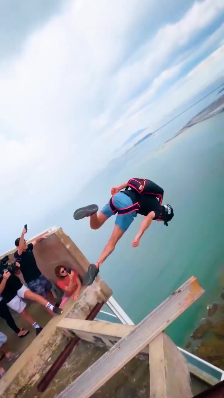 Wingsuit Flying Between Skyscrapers in Coastal City