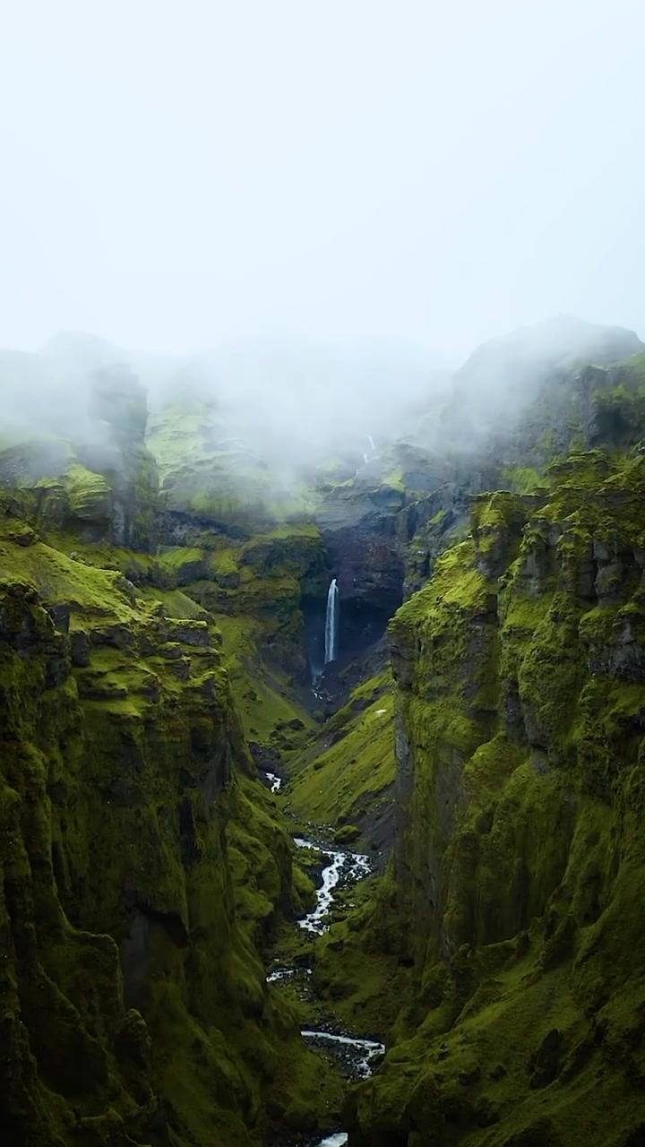 Aerial View of Waterfall in Lush Canyon