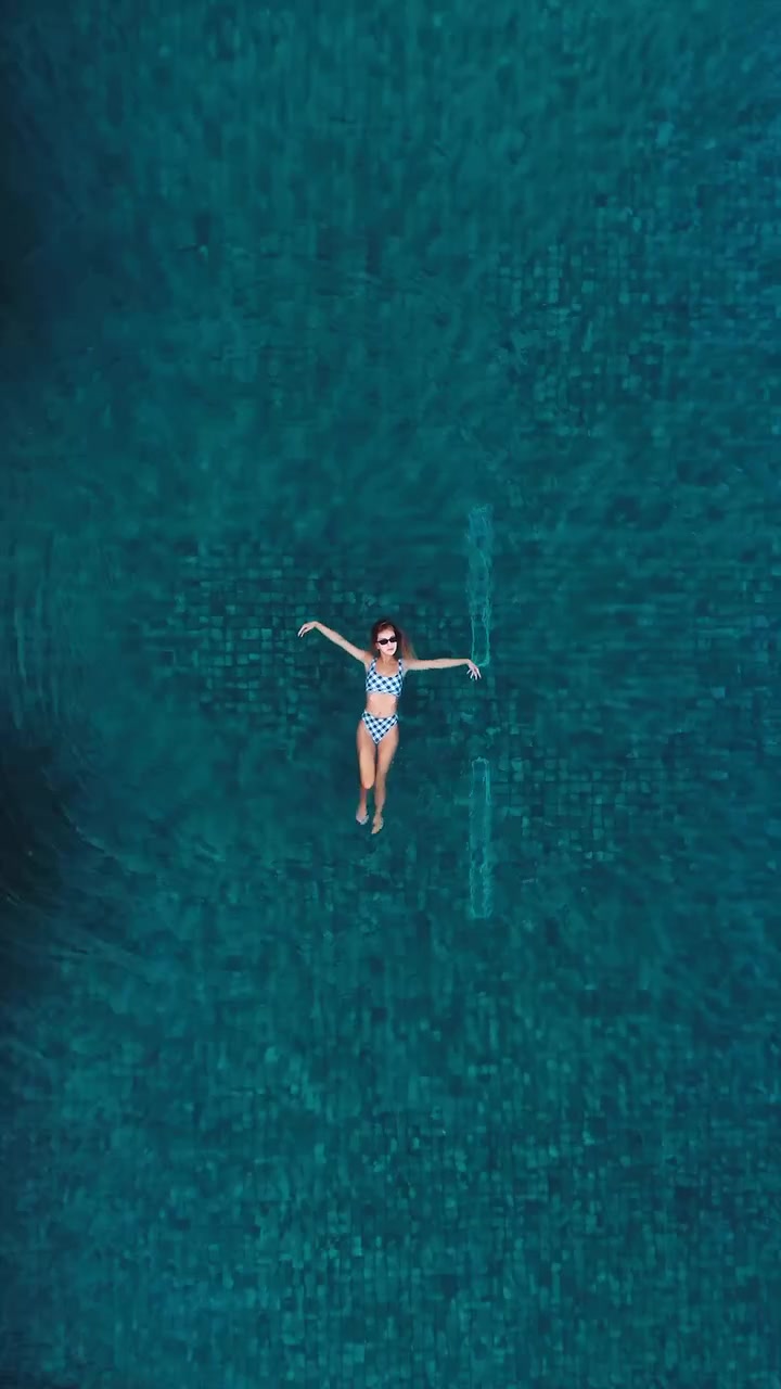 Aerial View of Woman Swimming in Luxurious Pool