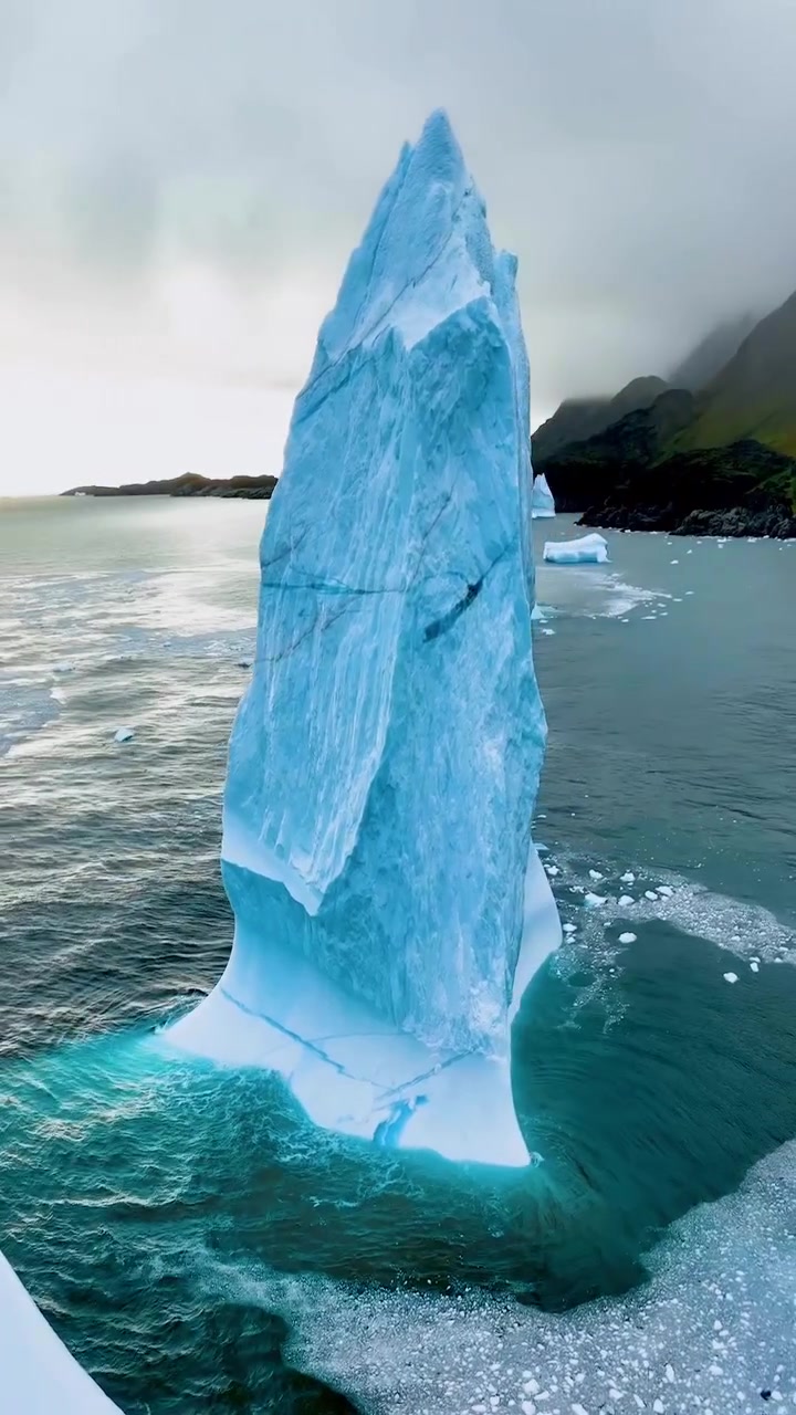 Aerial View of Large Blue Iceberg in Ocean