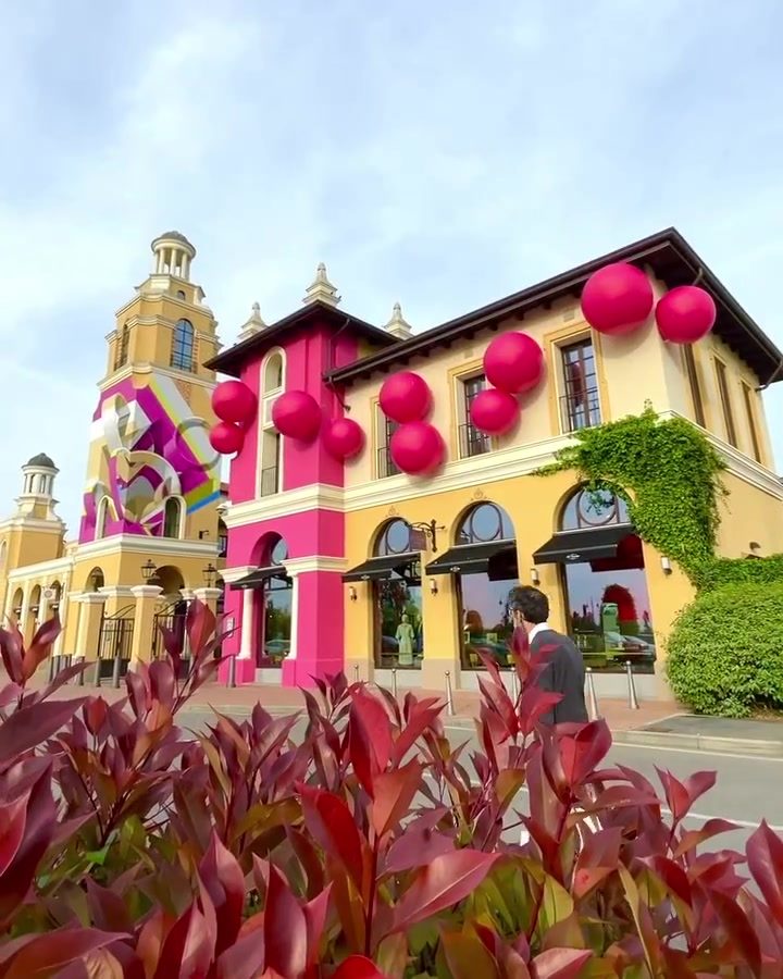 Spanish-Style Building Transformation with Pink Balloons