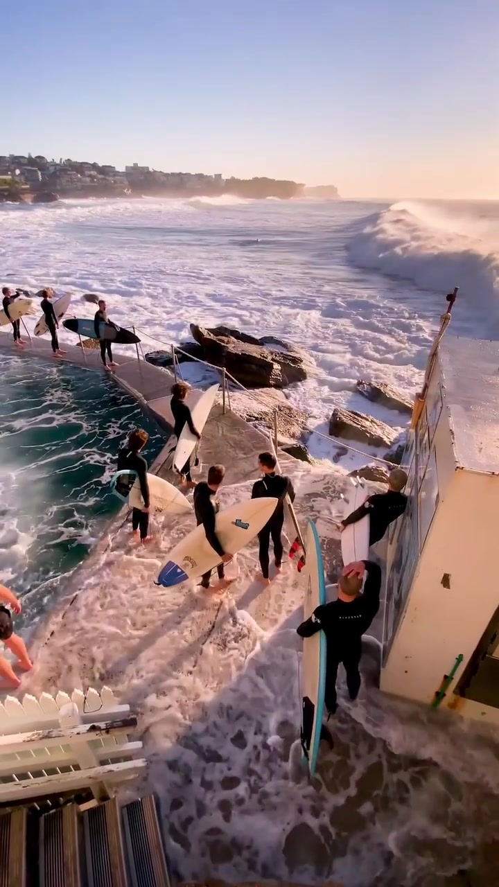 Surfers Tackle Large Waves Near Rocky Coastline