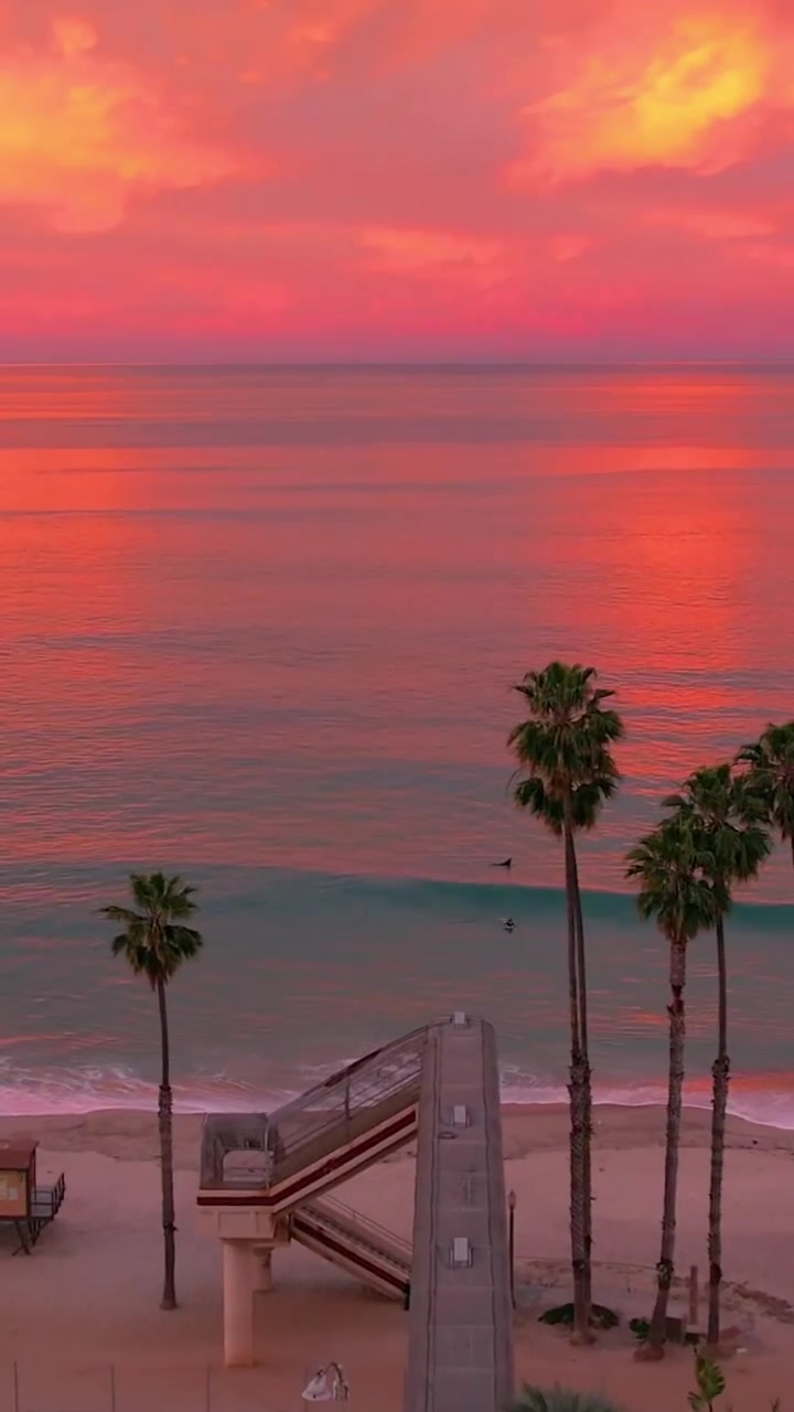 Sunset Beach Scene: Surfer, Palm Trees, Vibrant Hues