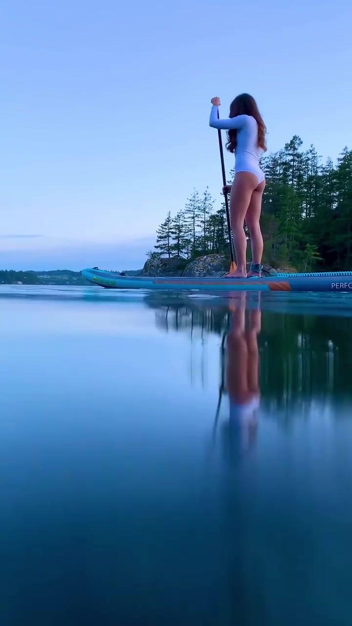 Paddleboarding at Dusk: Calm Lake Reflection