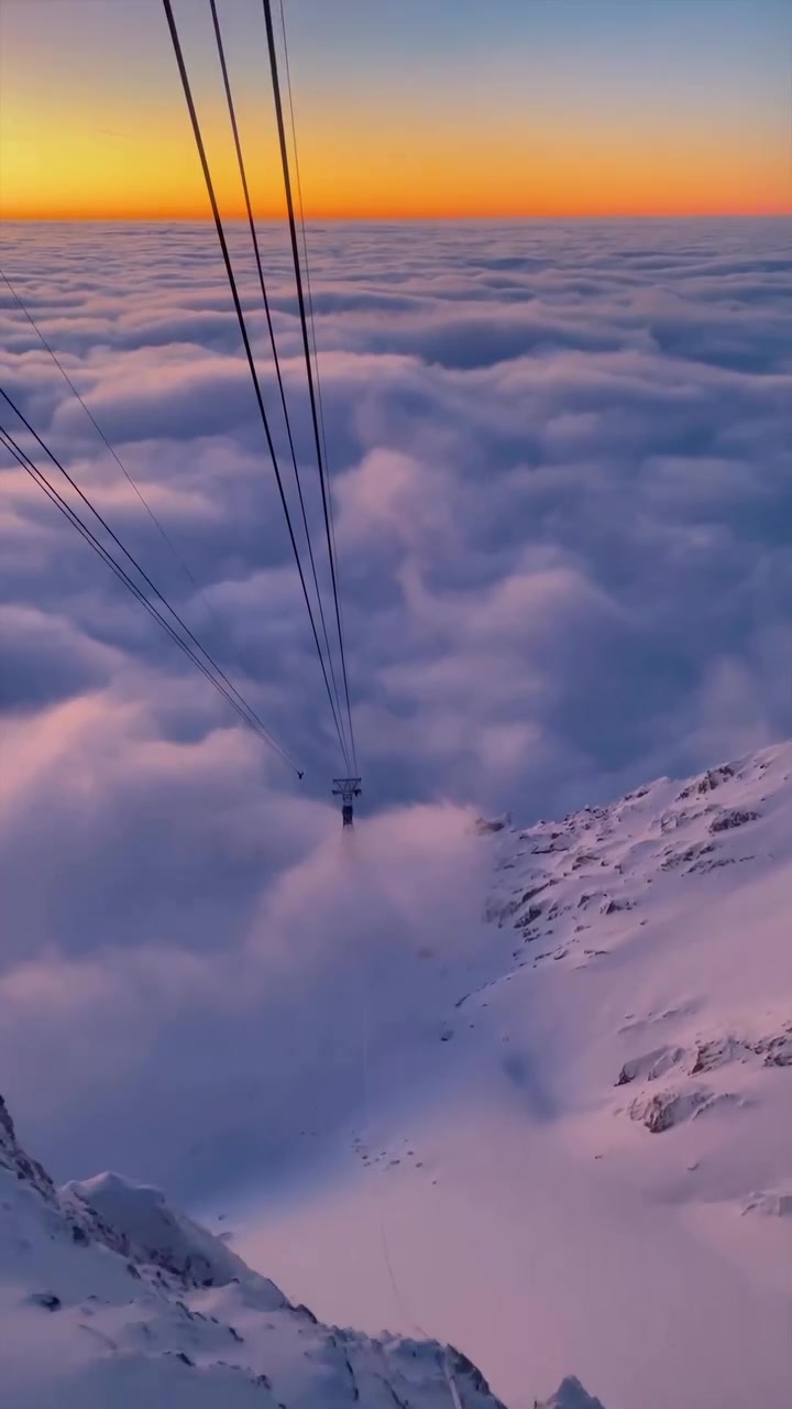 Gondola Ride: Aerial Views of Mountains and Clouds