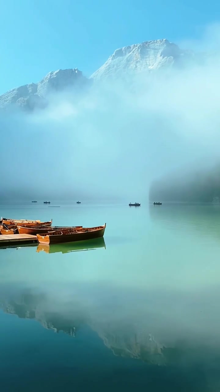 Serene Lake Landscape with Wooden Boats and Misty Mountain